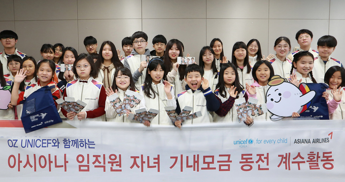 지난 17일 강서구 아시아나항공 교육훈련동에서 겨울방학을 맞이한 임직원 자녀들이 '사랑의 기내 동전 모으기 캠페인'으로 모인 동전의 계수 봉사활동에 참여해 기념사진을 찍고 있다.