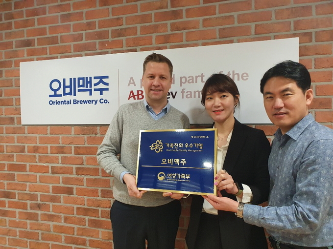 오비맥주가 '여성가족부'가 수여하는 '2019 가족친화인증기업'에 선정됐다. 오비맥주 배하준 대표(왼쪽)와 임직원들이 기념촬영을 하고 있다.