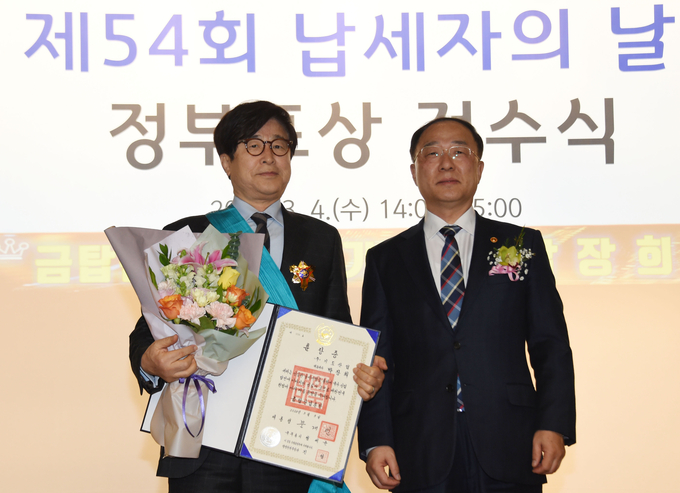 홍남기 부총리 겸 기획재정부 장관이 4일 오후 서울 중구 은행연합회에서 열린 '제54회 납세자의 날' 정부포상 전수식에서 (주)기도산업 박장희 대표이사에게 금탑산업훈장을 전수하고 있다.