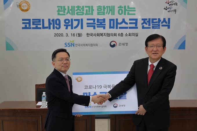 노석환<왼쪽> 관세청장이 서상목 한국사회복지협의회장에게 몰수된 보건 마스크를 기증하고 있다.