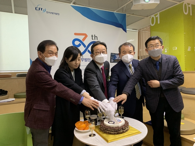천지세무법인 임직원들이 기념 떡케이크 앞에서 30주년 축하 이벤트를 하고 있다. 