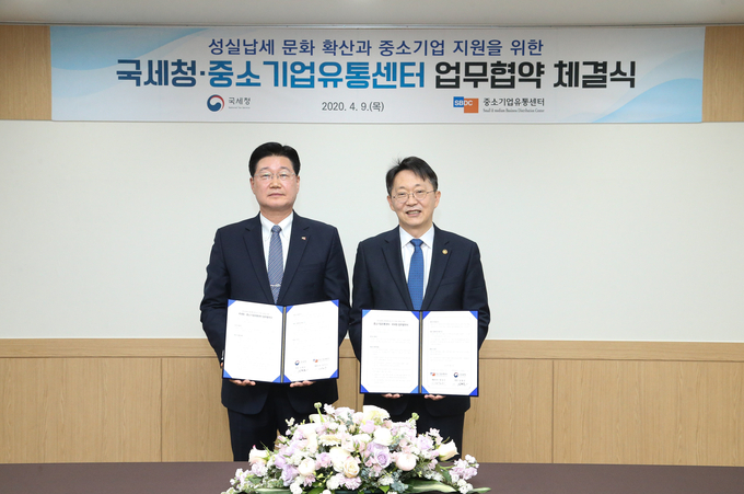 김현준(오른쪽) 국세청장과 정진수 중소기업유통센터 대표이사가 9일 서울지방국세청사에서 업무협약서에 서명하고 기념촬영하고 있다.