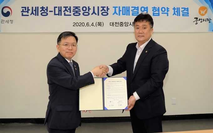 노석환(왼쪽) 관세청장은 4일 코로나19로 판매부진을 겪고 있는 지역 전통시장인 대전중앙시장과 자매결연 협약식을 체결했다.