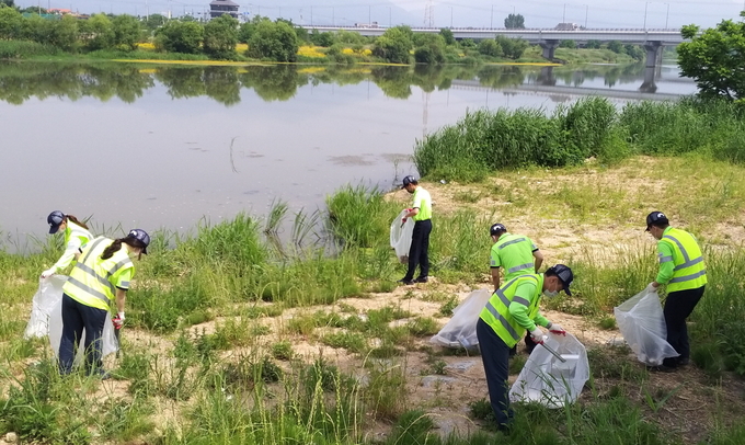 오비맥주 광주공장 임직원들이 공장 외곽과 영산간 일대를 돌며 각종 쓰레기와 수중 부유물을 제거하는 하천 정화활동을 펼치고 있다.