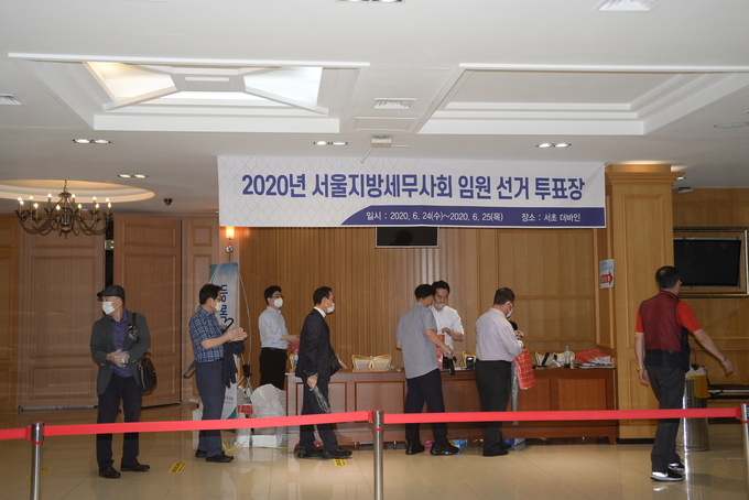 투표를 마친 회원들이 기념품을 수령해 돌아가고 있다.