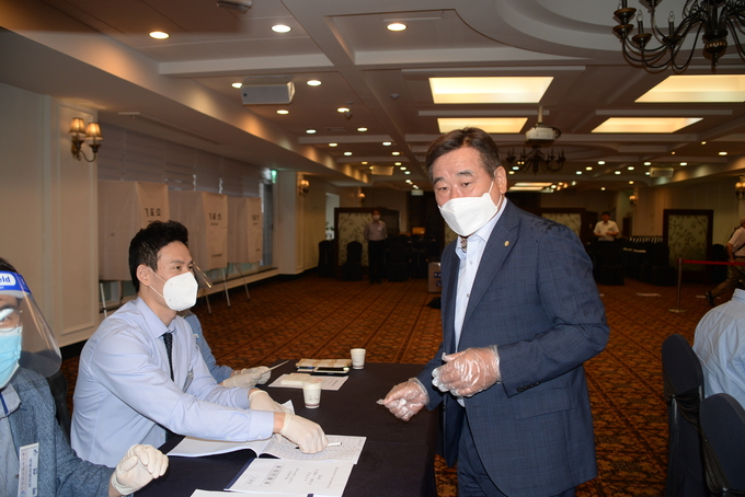투표장을 찾은 임채룡 현 서울지방세무사회장(오른쪽)을 선관위 직원들이 페이스 마스크를 쓰고 맞이하고 있다.