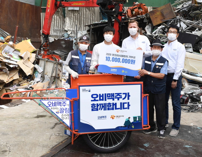 8일 서울 송파구 주신자원 고물상에서 열린 '2020 캔크러시 챌린지' 환경 캠페인 기부금 전달식에서 오비맥주 배하준 대표(오른쪽 세 번째)와 오비맥주 장유택 부사장(오른쪽 첫 번째), 소셜벤처 끌림 송형우 대표(왼쪽 두 번째)가 재활용품 수거 어르신들과 기념촬영을 하고 있다.