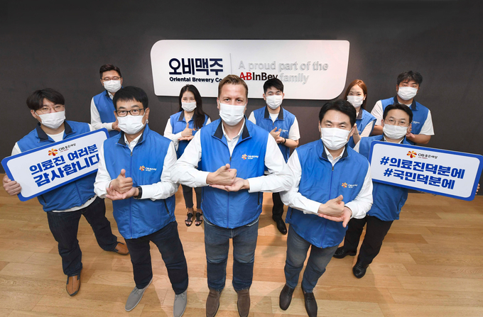 오비맥주 배하준 대표(맨 앞줄 가운데)가 10일 삼성동 본사에서 임직원들과 함께 #덕분에챌린지 캠페인에 동참하고 있다.
