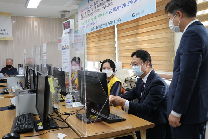 이동신 부산청장<오른쪽 두 번째>이 지난 21일 창원세무서 신고창구에서 신고서 작성을 시연하고 있다.