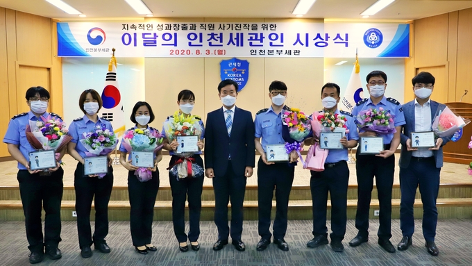 김윤식 인천세관장(왼쪽 다섯번째)이 '7월의 인천세관인'으로 선정된 김미현 관세행정관과 업무 분야별 유공자들과 기념촬영하고 있다.