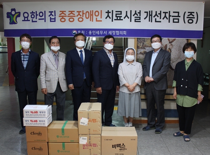 이한성 용인세무서 세정협의회장<사진 중앙>과 윤영일 용인세무서장<왼쪽 세번째>이 장애인 복지시설 요한의 집을 찾아 추석 위문품과 격려금을 전달하고 있다.