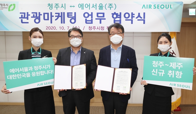 에어서울과 청주시가 청주-제주 첫 취항을 맞아 7일 '관광 협력 협약'을 체결하고 기념사진 촬영을 하고 있다.(왼쪽부터 에어서울 캐빈승무원, 에어서울 조진만 경영본부장, 김항섭 청주시 부시장, 에어서울 캐빈승무원)