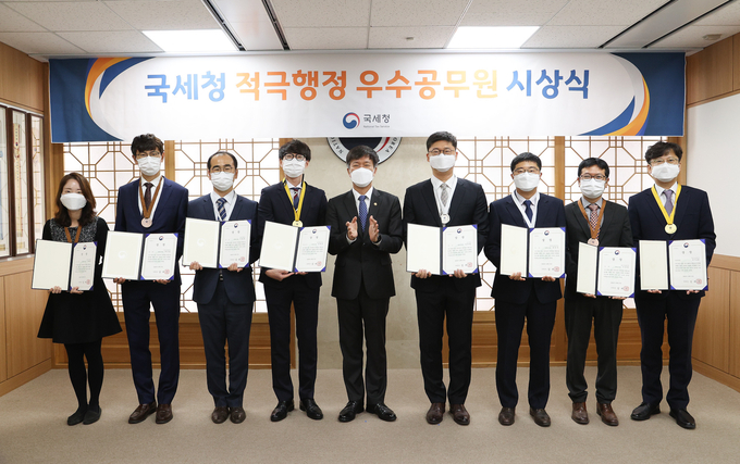 김대지 국세청장(가운데)이 3차 국세청 적극행정 우수공무원으로 선정된 직원들과 기념촬영하고 있다.
