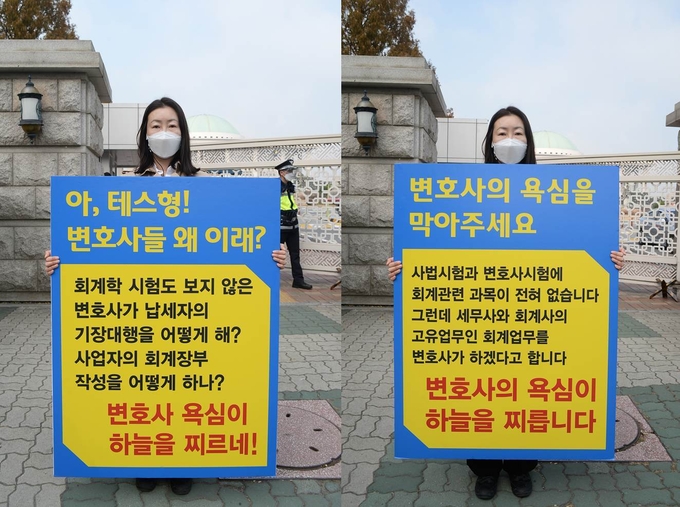 13일 국회 앞 1인 시위에 나선 배미영 고시회 상임이사가 피켓을 들고 서 있다.