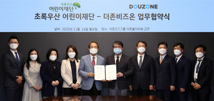 더존비즈온과 초록우산 어린이재단이 지난 16일 ‘비영리 및 사회복지 분야 재정 투명성 제고’에 관한 업무협약을 체결한 가운데, 더존비즈온 김용우 회장(사진 중앙 오른쪽)과 초록우산 어린이재단 이제훈 회장(사진 중앙 왼쪽)이 양해각서를 교환하고 있다.