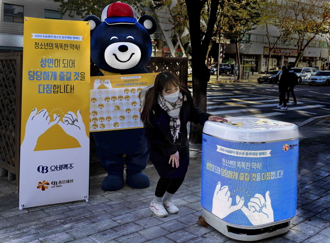 오비맥주는 2021학년도 대학수학능력시험일인 지난 3일 오후 강남구 삼성동 일대에서 비대면 청소년 음주 예방 캠페인을 펼쳤다. 수험생이 자율주행 로봇에게 술은 언제부터 마실 수 있는지 질문하자 "술은 성인이 되어 당당하게 즐기세요"라고 답변하고 있다.