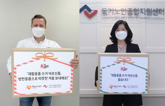 오비맥주 배하준 대표(왼쪽)와 김현미 독거노인종합지원센터장이 재활용품 수거 어르신을 위한 방한용품 지원 비대면 전달식에 참석해 기념촬영을 하고 있다.