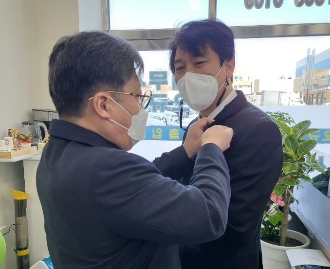 정성균 광주지방세무사회장(왼쪽)이 지난 8일 개업한 오규성 세무사에게 세무사 배지를 패용하고 있다.