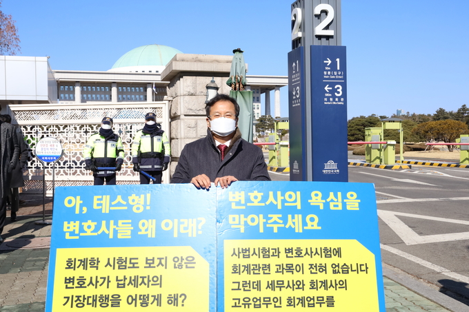 이금주 인천지방세무사회장이 지난 8일 국회 앞 1인 시위 릴레이에 참여해 피켓을 들고 있다.