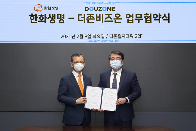 더존비즈온 김용우 대표(오른쪽)와 한화생명보험 여승주 대표가 업무협약서를 교환하고 있다.