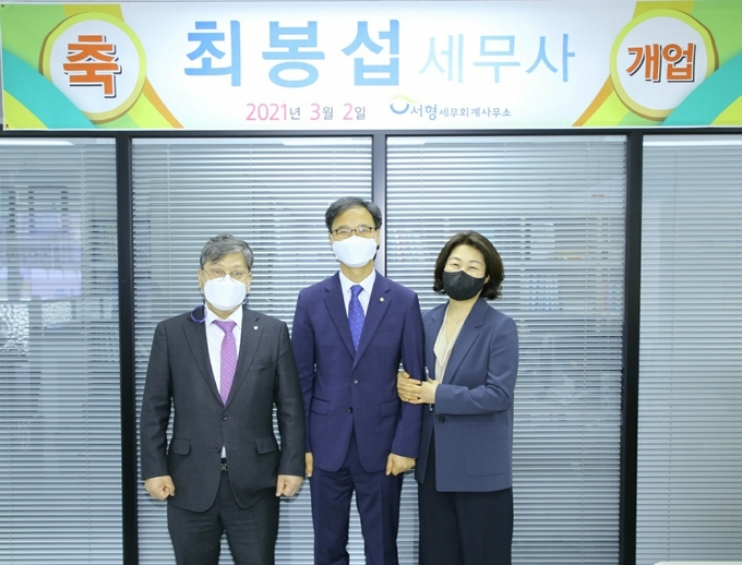 최봉섭 세무사(가운데)가 정성균 광주지방세무사회장<왼쪽>, 배우자와 함께 기념촬영을 하고 있다.