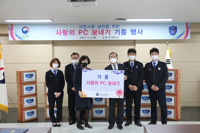 김재홍 김포공항세관장(중앙 오른쪽)과 김성희 한국장애인IT고용협회 본부장(중앙 왼쪽)이 김포공항세관 직원들과 함께 기념촬영을 하고 있다.(사진=김포공항세관)