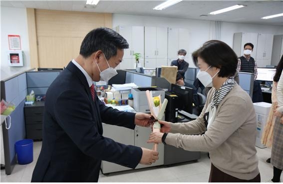 이진우 서장<왼쪽>이 화이트데이를 기념해 관내 소상공인으로부터 구매한 장미꽃 한 송이를 직원에게 전달하고 있다.<사진=금천세무서>