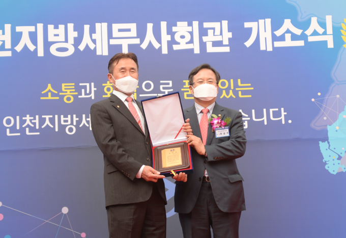 이금주 인천회장<오른쪽>에게 유윤상 부회장이 회원들을 대표해 공로패를 수여하고 있다.