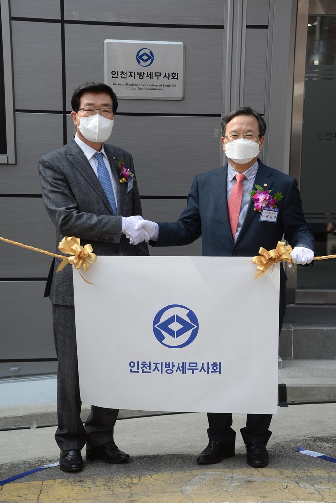 원경희 한국세무사회장<왼쪽>과 이금주 인천지방세무사회장이 현판 제막식 후 기념사진을 촬영하고 있다.