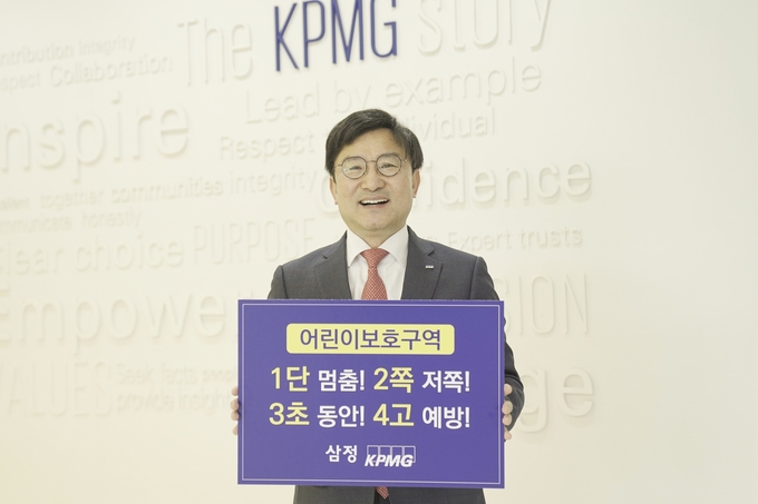 구승회 삼정KPMG 재무자문부문 대표가 어린이 교통안전 슬로건을 들고 기념촬영을 하고 있다. (사진=삼정KPMG)
