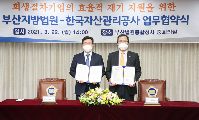 문성유 캠코 사장<오른쪽>과 전상훈 부산지방법원장이 '회생절차기업의 효율적 재기 지원을 위한 업무협약'을 체결하고 기념사진 촬영을 하고 있다.(사진=캠코)
