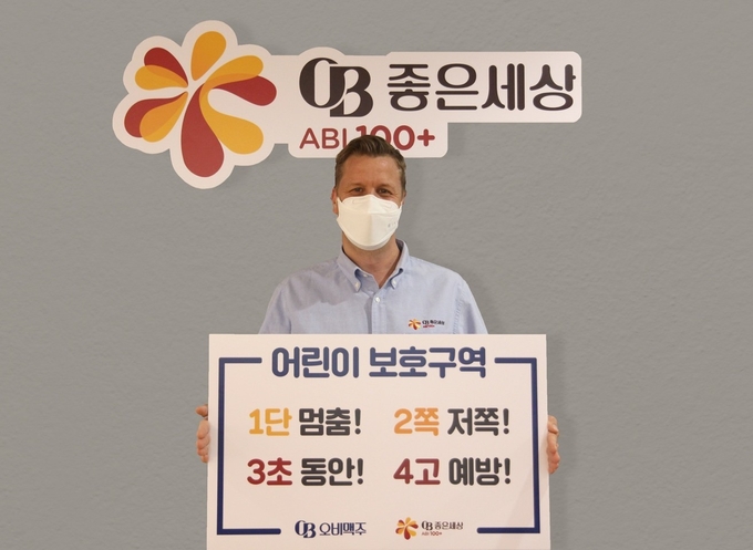 오비맥주 배하준 대표가 "1단 멈춤! 2쪽 저쪽! 3초 동안! 4고 예방!" 표어를 들고 '어린이 교통안전 릴레이 챌린지'에 참여하고 있다.