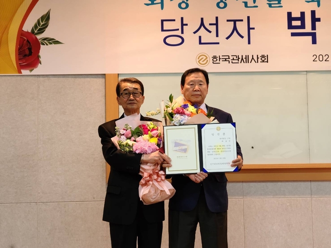 박창언(왼쪽) 제26대 한국관세사회장이 황규환 관세사회 선거관리위원장에게 당선증을 받고 있다.