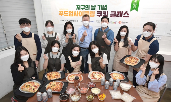 오비맥주 배하준 대표(두번째 줄 왼쪽 4번째)와 리하베스트 민명준 대표(두번째 줄 왼쪽 5번째)가 20일 열린 '맥주박 업사이클링 쿠킹클래스'에서 기념 촬영을 하고 있다.(사진=오비맥주)