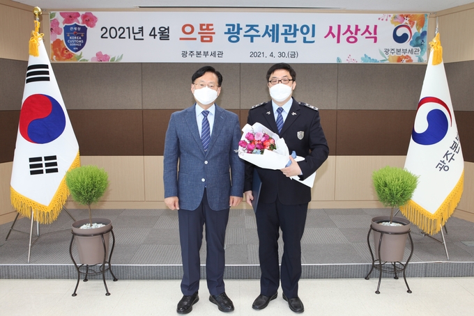 성태곤(왼쪽) 광주세관장이 4월의 '으뜸 광주세관인'으로 선정된 정요섭 수출입기업지원센터 관세행정관과 기념촬영하고 있다.
