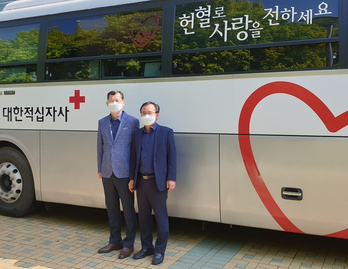 정호창(오른쪽) 인천공항국제우편세관장과 박상태 국제우편물류센터장이 헌혈버스 앞에서 기념촬영하고 있다.(사진=인천공항국제우편세관)