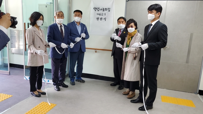 조용근 회장을 비롯한 준공식 참석자들이 현판식을 갖고 있다.