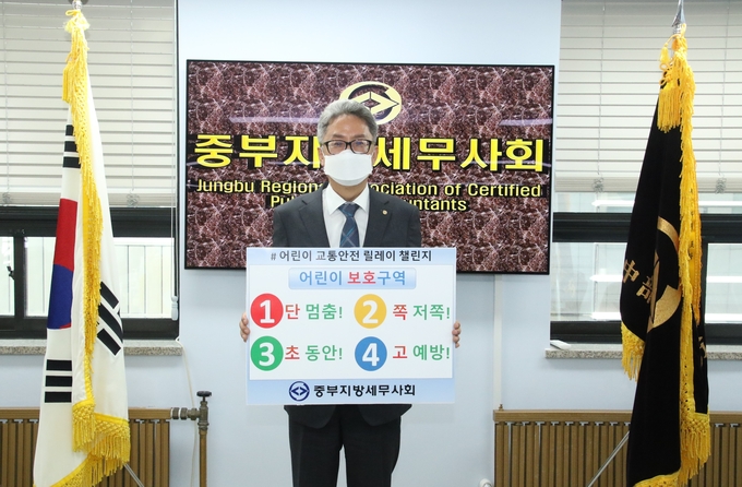 유영조 중부세무사회장은 13일 ‘1단 멈춤, 2단 저쪽, 3초 동안, 4고 예방’이라 적힌 교통안전 표어를 들고, 어린이 교통안전 릴레이 챌린지에 참여했다.(사진=중부세무사회)