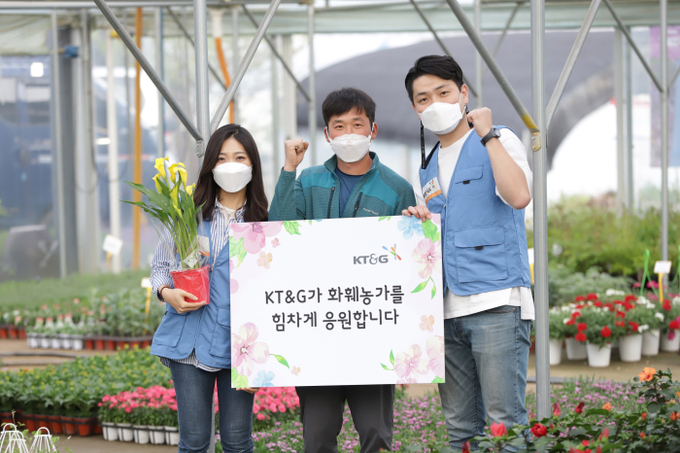 KT&G 임직원 봉사단이 화훼농가 현장을 방문해 화훼농가인과 기념 사진촬영을 하고 있다.(사진=KT&G)