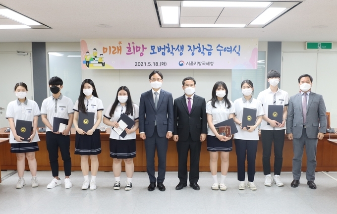임광현 서울청장(왼쪽 다섯번째)이 지난 18일 대동세무고 학생 7명에게 장학금과 도서를 전달하고 기념사진을 찍고 있다.(사진=서울청)
