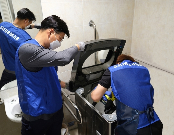  삼성전자서비스 임직원이 가전 세척·점검 재능기부를 하고 있다.(사진=삼성전자)