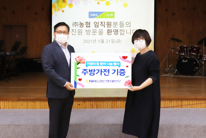 임동순 부행장(왼쪽)이 인천 미추홀구 소재 아동복지시설인 향진원을 방문해 신언희 원장과 기념촬영을 하고 있다.(사진=NH농협은행)