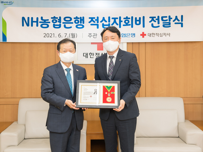 권준학 은행장(오른쪽)이 신희영 회장으로부터 최고명예대장을 받고 기념촬영을 하고 있다.<사진=농협은행>