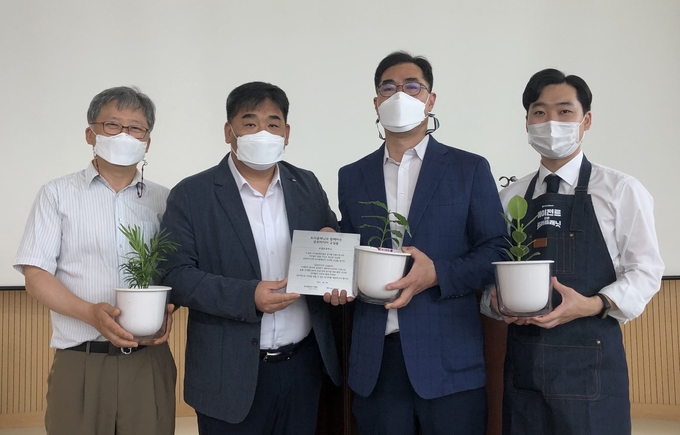 금호타이어는 9일 서울 관악구 조원초등학교에서 금호타이어와 함께 하는 교실숲' 현판 전달식을 가졌다.(왼쪽부터) 서진수 교감, 금호타이어 강진구 경영지원팀장, 석승하 교장, 트리플래닛 김형수 대표가 공기정화 식물을 들고 '기념촬영을 하고 있다.(사진=금호타이어)