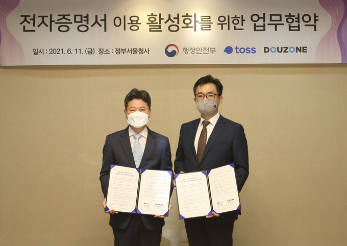 더존비즈온과 행정안전부가 ‘전자증명서 이용 활성화를 위한 업무협약’을 체결한 가운데, 더존비즈온 송호철 플랫폼사업부문 대표(오른쪽)와 행정안전부 한창섭 정부혁신조직실장이 협약서를 교환하고 있다.<사진=더존비즈온>