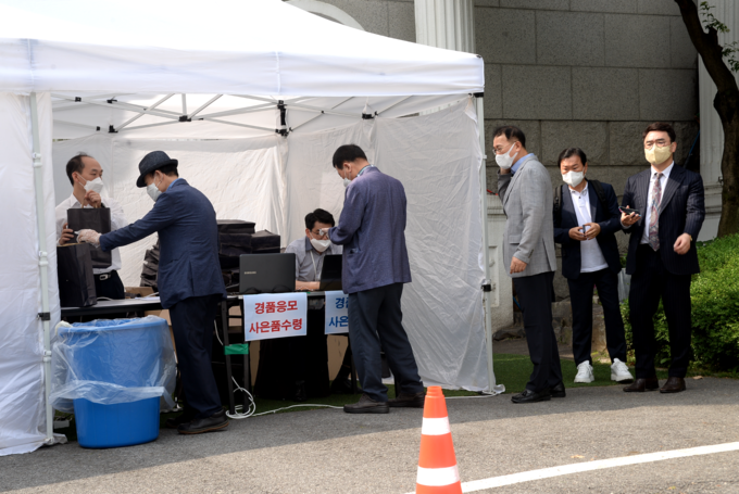 투표에 참여한 세무사들이 사은품 수령 부스에서 기념품을 받고 있다. 