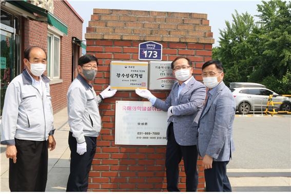장수성실기업 (주)무궁화 입간판 앞에서 관계자들이 기념촬영하고 있다. 