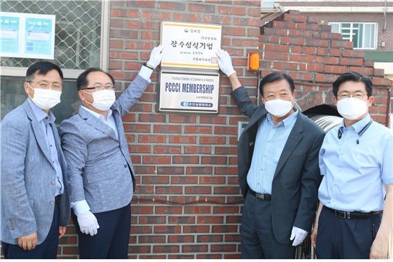 관계자들이 장수성실기업으로 선정된 대성산업사 입간판을 부착하고 있다. 