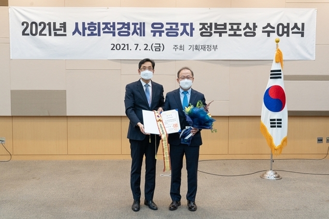 이상학 KT&G 지속경영본부장(오른쪽)이 ‘2021 사회적경제 유공자’ 대통령표창 수여식에 참석해 기념촬영을 하고 있다.(사진=KT&G)