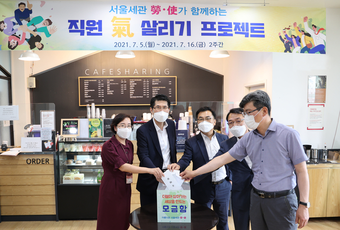김광호 서울세관장(왼쪽 두번째)이 청사 내 나눔 카페에서 모금함에 기부금을 넣고 기념촬영을 하고 있다.